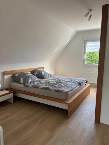 a bedroom with a bed with a wooden frame and a window at Ferienwohnung Ruhepunkt Dessau - zentral nahe Bauhaus und Meisterhäusern - mit gratis WLAN und Parken sowie Komplettküche in Dessau