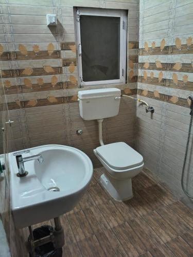 a bathroom with a white toilet and a sink at Hotel Radhika Palace in Mirzāpur