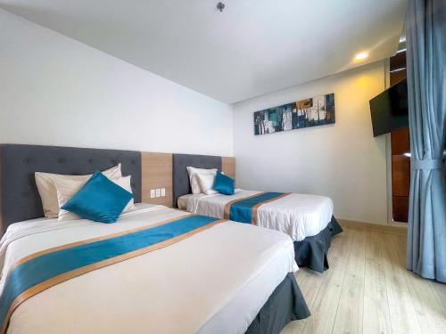 a hotel room with two beds and a television at Villas 930 Oceanami in Long Hai