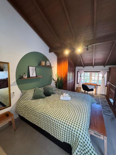 a bedroom with a bed with a green headboard at Chalé da Praia Paraty in Paraty