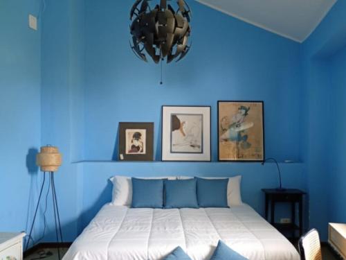 a blue bedroom with a bed with a blue wall at MaNi Madre in Giarre