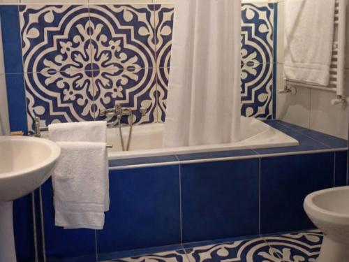 a blue and white bathroom with a tub and a sink at MaNi Madre in Giarre