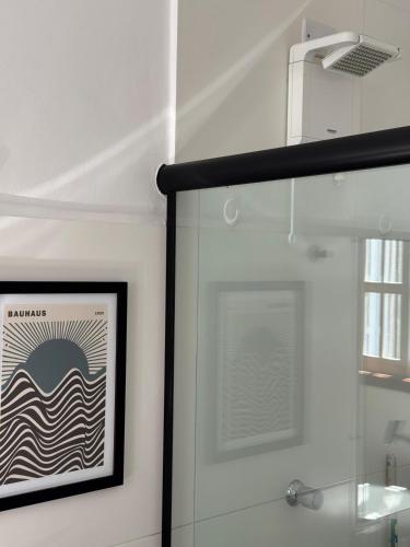 a framed picture on a wall next to a shower at Chalé da Praia Paraty in Paraty