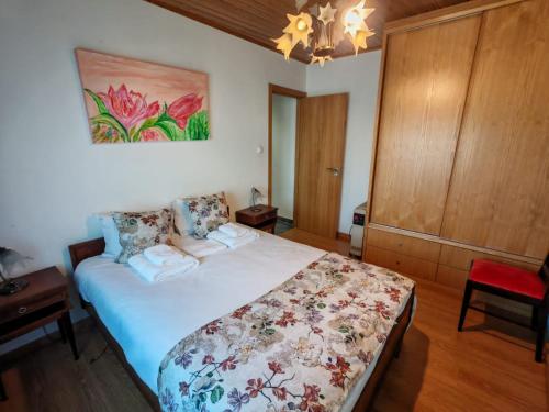 a bedroom with a bed and a painting on the wall at Malhadinhas House in Vila Nova de Paiva