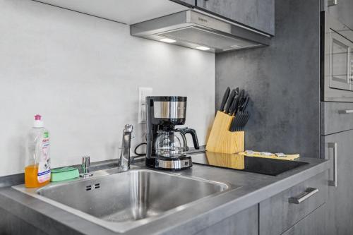 a kitchen sink with a mixer on top of it at NORA Tiny House Bergheider See in Buschmühle