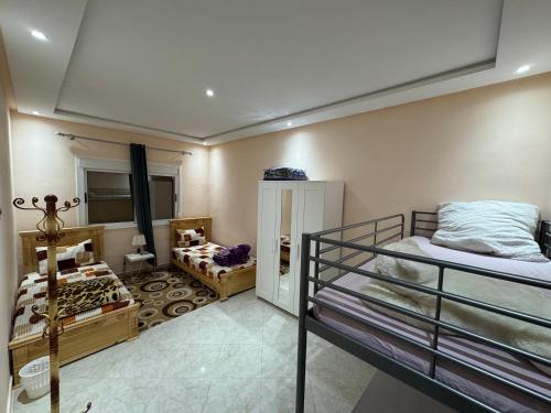 a bedroom with two bunk beds and a room with two beds at Lixus Appartement- 1h Stadion & Airport Tanger in Larache