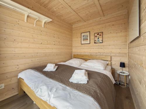 a bedroom with a bed in a wooden cabin at NORA Tiny House Bergheider See in Buschmühle