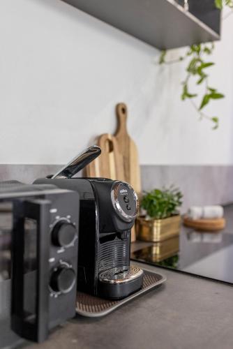 a black toaster sitting on a counter next to a toaster at XX Settembre Studio Apartment in Parma