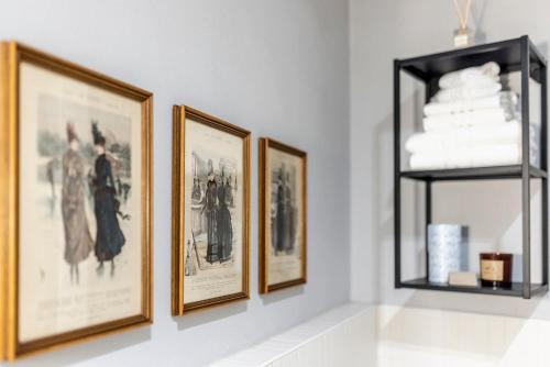 a group of pictures on a wall with a shelf at XX Settembre Studio Apartment in Parma