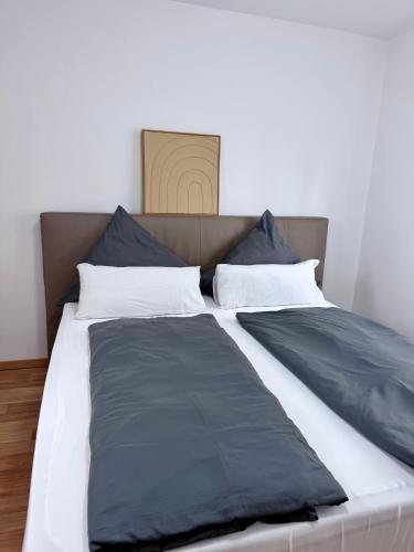a large bed with black and white pillows on it at Haus 87a Apartment 2 in Oberkirch