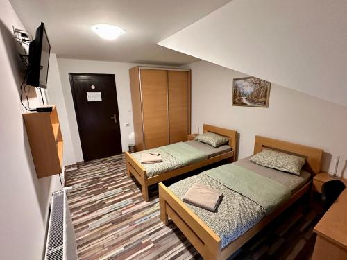 a small room with two beds and a television at Prenoćište Šoderica in Legrad
