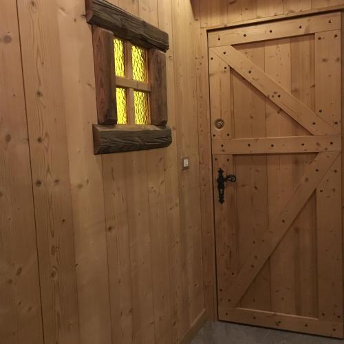 a door in a log cabin with a window at Le grenier des rêves in Les Deux Alpes