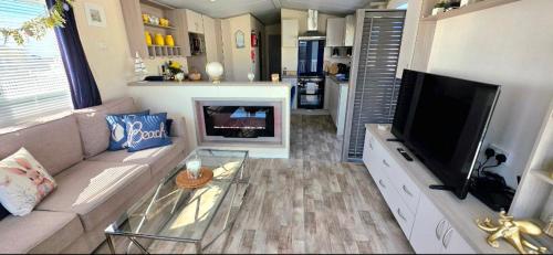 a living room with a couch and a flat screen tv at Blue Lagoon Holiday ,Bude 79 in Cubert