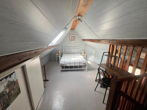 a attic room with a bed and a staircase at Gîte des sabotiers in Le Boissenet