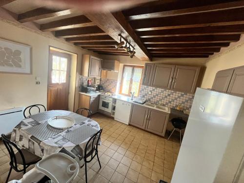 a kitchen with a table and a kitchen with a table and chairs at Gîte des sabotiers in Le Boissenet