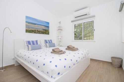 a white bedroom with a bed in a room at Casa Caribe by Algarve Holidays in São Brás de Alportel