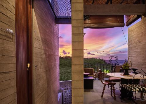 a view of a sunset from the balcony of a house at Orama Bali in Uluwatu