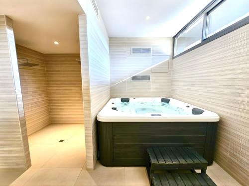 a bathroom with a tub and a shower with a window at Eden50 in Mijas Costa