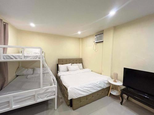 a bedroom with two bunk beds and a flat screen tv at Casa de Matilda in Silang