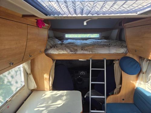 a small bed in the back of a camper van at Le Maillotin en balade in Les Maillys