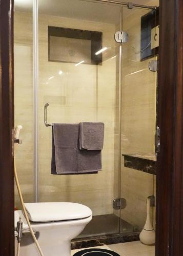 a bathroom with a toilet and a glass shower at Autumn House in Jaipur