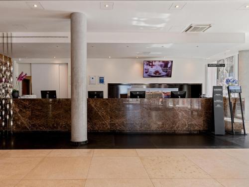 a lobby with a bar in a building at Park Inn by Radisson Meriton Conference & Spa Hotel Tallinn in Tallinn