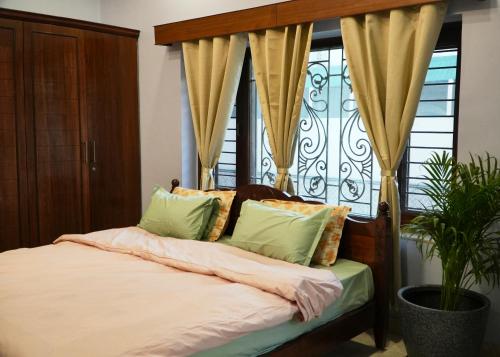 a bedroom with a bed and a window with curtains at Autumn House in Jaipur
