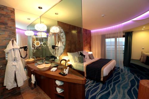 Hotel Cascade Resort & Spa في ديمجين: غرفة نوم مع سرير وغطاء مع مرآة
