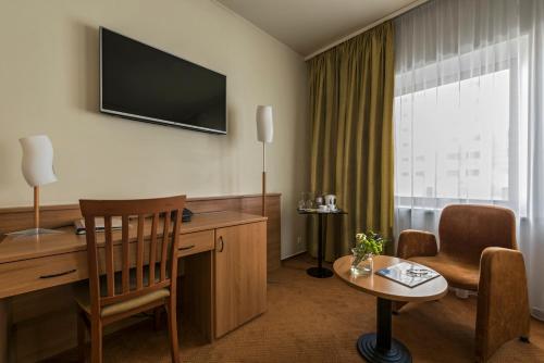 a hotel room with a desk and a chair at BEST BALTIC Kaunas in Kaunas