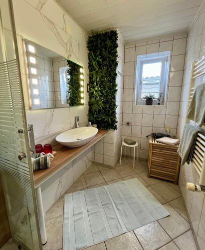 a bathroom with a sink and plants on the wall at Garden Paradise Bled Apartments - garden, pond and castle view in Bled