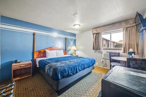 a hotel room with a bed and a desk at Travelodge by Wyndham Kanab in Kanab