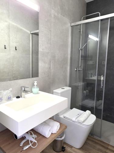 a bathroom with a sink and a shower and a toilet at HOSTAL CASA EMILIO in Almería