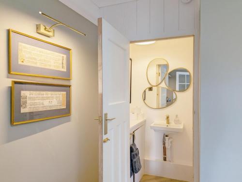 a bathroom with a sink and a mirror at Thimble Cottage - Emsworth in Emsworth