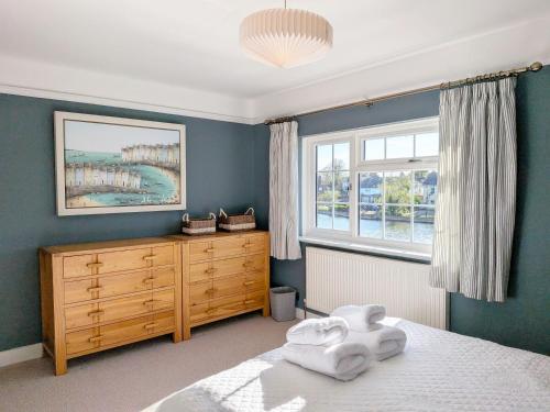 a bedroom with a bed and a dresser and a window at Thimble Cottage - Emsworth in Emsworth