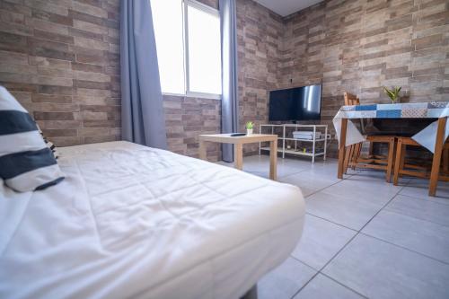 a bedroom with a bed and a table and a television at Edificio Prieto VIV 5 in Puerto del Rosario