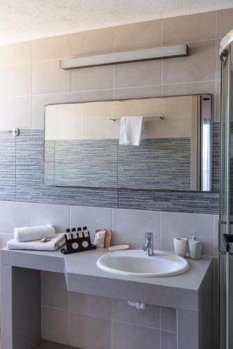 a bathroom with a sink and a mirror at Arlen Beach Hotel in Hersonissos