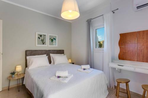 a bedroom with a bed with two towels on it at Villa Areva by Villa Plus in Panormos Rethymno