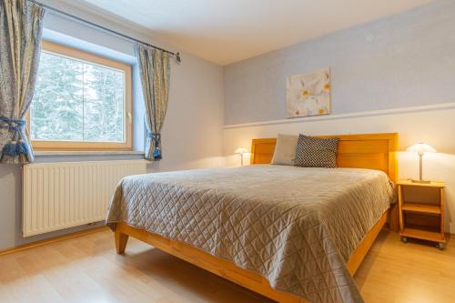 a bedroom with a bed and a window at Haus Wörle- Ferienwohnung "Hahle" in Musau
