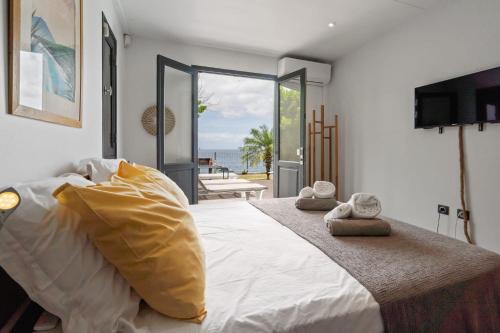 a bedroom with a bed with a view of the ocean at Villa lEscale de Sainte Philomène in Saint-Pierre