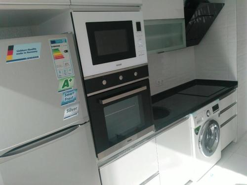 y cocina con microondas y lavadora. en Zaher Apartment, en Bursa