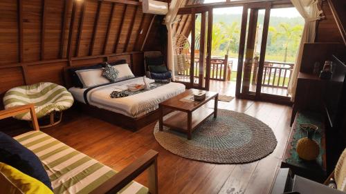 a living room with a bed and a table at Cascadia Rad Villa in Jatiluwih