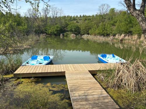 two boats sitting on the water next to a dock at Lodge 101 at Eden Reserve Near Ark in Williamstown