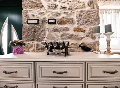 a white dresser in a room with a stone wall at La Felicita in Gornji Zemunik