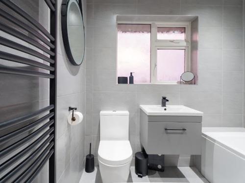 a bathroom with a toilet and a sink and a mirror at Modern tyne & wear house in North Tyneside