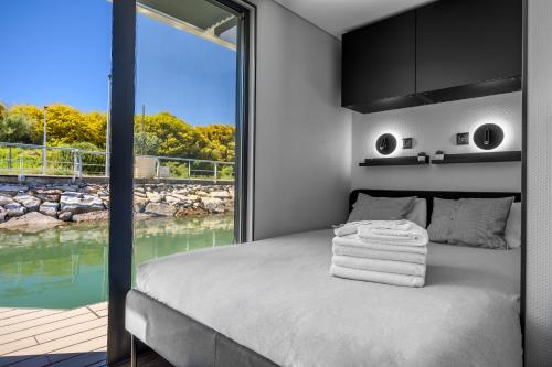 a bedroom with a bed with a large window at The Homeboat Company Albufeira in Albufeira