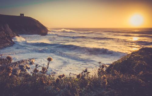 a view of the ocean with the sun in the distance at Hostel albergue Paradiso in Hinojedo