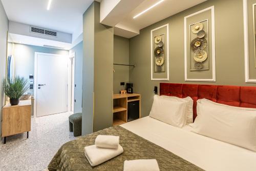 a bedroom with a large bed with a red headboard at Ernest Suites Psiri in Athens