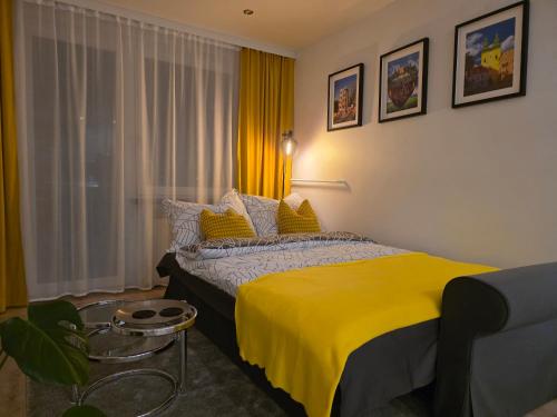 a bedroom with a yellow bed and a window at Perełka Południa in Głuchołazy