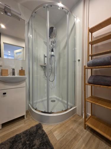 a bathroom with a glass shower and a sink at Perełka Południa in Głuchołazy