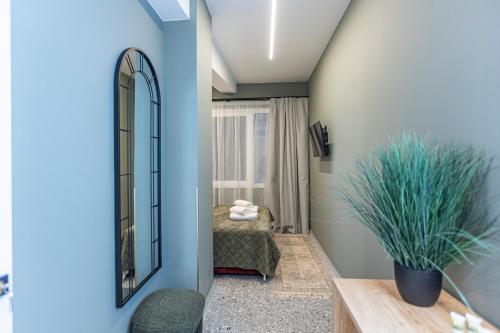 a dressing room with a mirror and a bed at Ernest Suites Psiri in Athens
